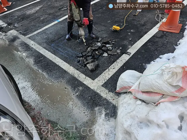 눈 쌓인 도로에서 배관을 굴착하는 작업